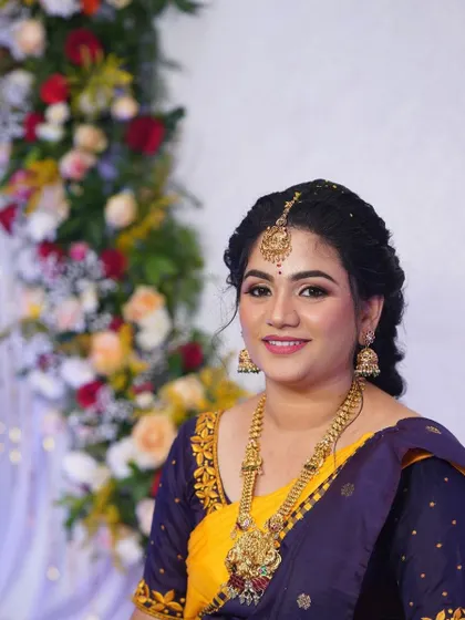 Shruthi's engagement look. The yellow and purple saree is a beautiful combination, and her makeup is kept classic and elegant.