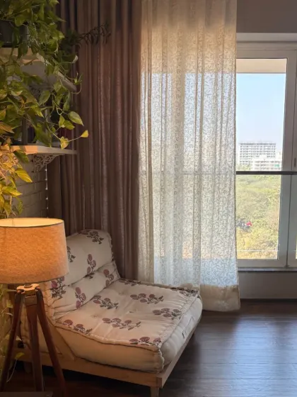 This cozy reading chair, upholstered in our floral fabric, is nestled in a corner filled with plants and soft light. Our curtains provide a neutral, calming backdrop for this peaceful spot.