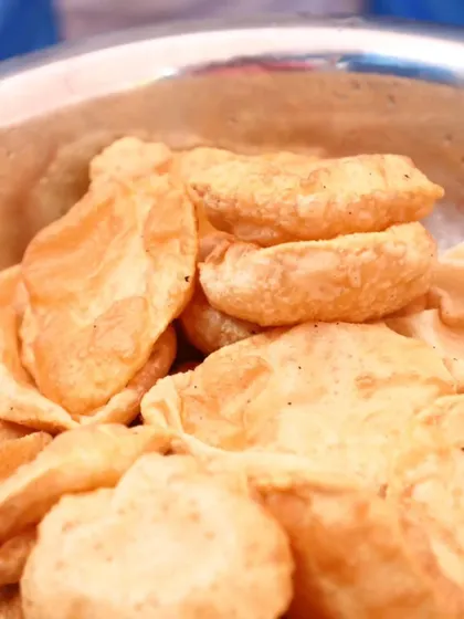 A bowl of hot and puffy pooris, a favorite at any celebration.