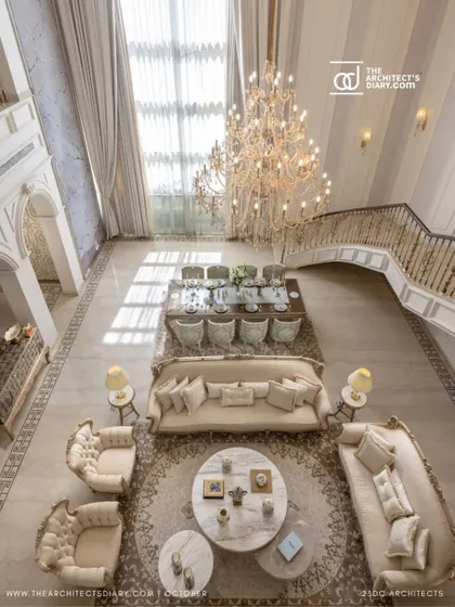 An overhead view of the main living area in The Ivory Royale. The circular rug anchors the seating arrangement, creating a sense of intimacy within the vast, double-height space.