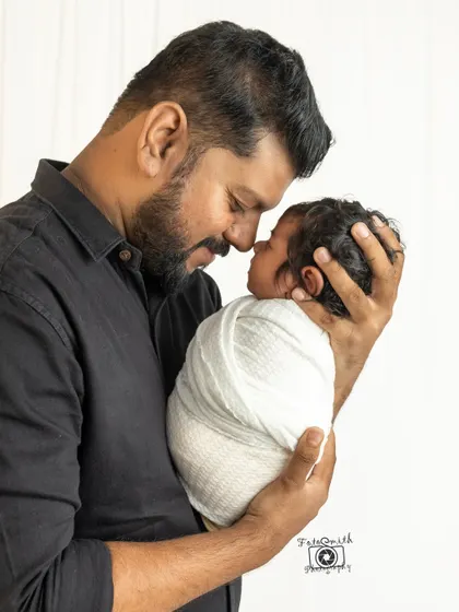 A father holds his swaddled baby, sharing a quiet moment face-to-face. This image captures the strength and gentleness of a new dad's love.