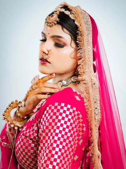 This shot highlights the intricate details of the blouse, nath, and maang tikka, all essential parts of the bridal ensemble.