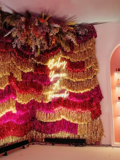 "Baby you're a firework!" This sparkling tinsel and neon sign photo booth was a huge hit, serving as a reminder for everyone to shine brightly.