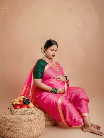 A quiet moment of reflection for the mother-to-be. The elephant motif in the background is a symbol of strength and good fortune, adding a deeper meaning to this traditional maternity portrait.