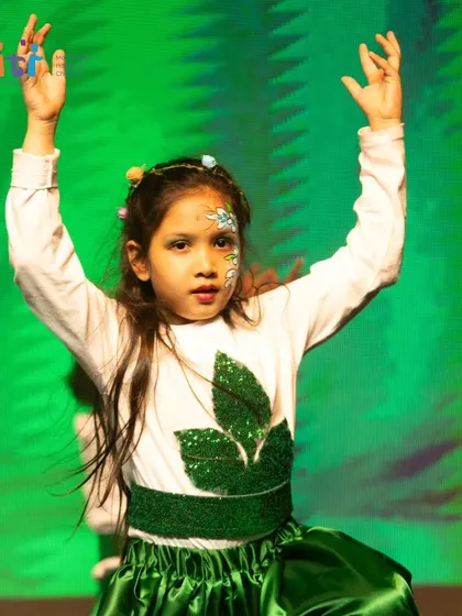 A girl in a leaf-themed costume strikes a pose, representing the plant life of our planet.