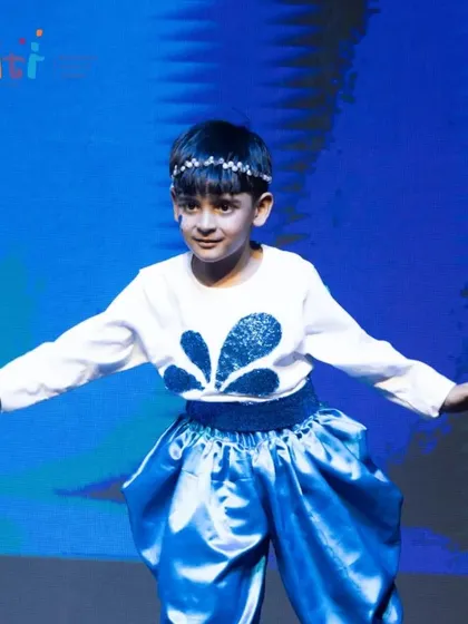 A solo performer dances as a raindrop, his movements fluid and graceful.