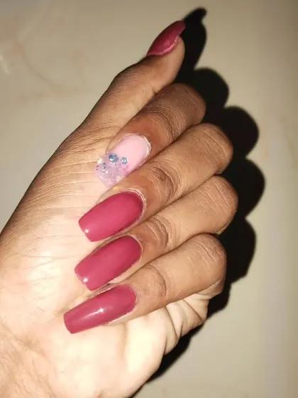 This design shows how a single accent nail can make a statement. I created a textured, shattered glass effect with rhinestones on the ring finger to complement the solid maroon nails.