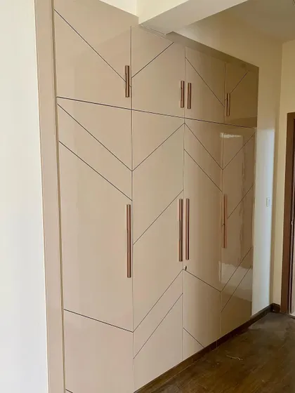 A large four-shutter wardrobe with a high-gloss finish and a modern geometric line design.