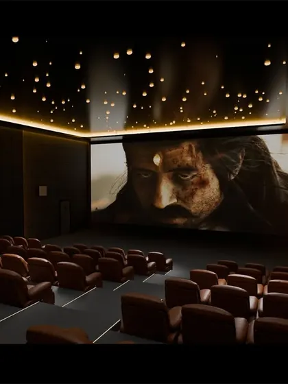 A rendering of a multiplex design, showcasing a dramatic ceiling with suspended light fixtures and perfectly tiered seating for optimal viewing angles from every seat.