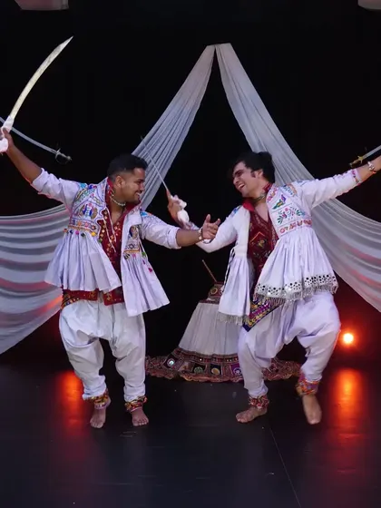 The energy between two performers is key in a duet like this. Here, we are captured mid-movement during a dynamic sword dance sequence, showcasing the precision and power involved.