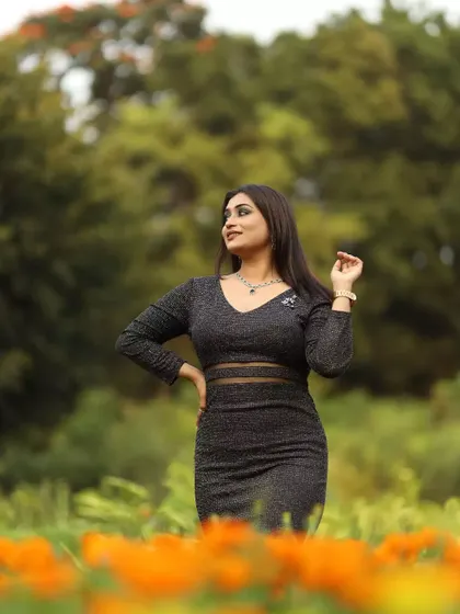 A full-length shot capturing the entire modern glam look, from the smokey eye makeup to the chic black dress.