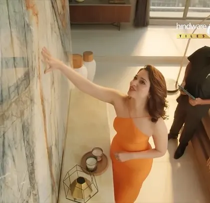 A different angle of Tamannaah inspecting the tiles. The overhead shot gives a unique perspective on the scene and her stylish outfit.