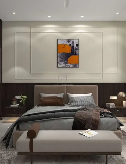 A bedroom from the 'Nivasa' project, designed with a focus on simplicity and warmth. The room includes a glass-fronted wardrobe, a built-in desk, and neutral tones with dark wood accents.