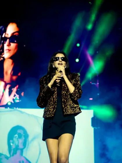 Shahat Gill looking cool and confident on the Social Nation stage. The screen in the background adds another layer to the composition, showing the event's branding.