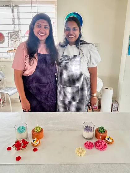 Two friends posing with their finished succulent and dessert candles. Our workshops are a great way to catch up and do something creative together.