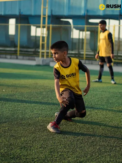 A player practices dynamic stretches as part of a warm-up.