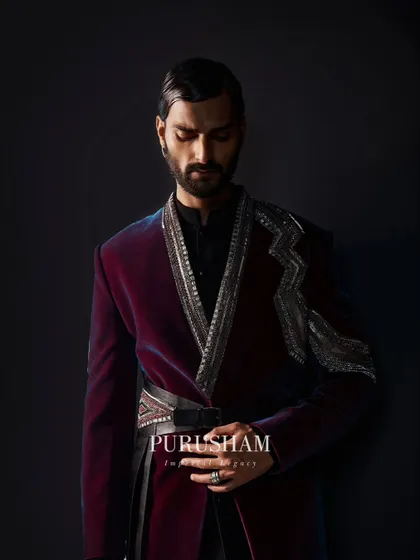 Illuminate every room with exquisite charm. This wine-colored velvet jacket, with its sharp shoulders and asymmetrical silver embroidery, is a study in quiet power.
