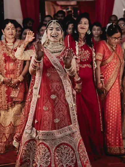 A joyous bridal entry, with the bride dancing her way in, surrounded by family and sparklers.