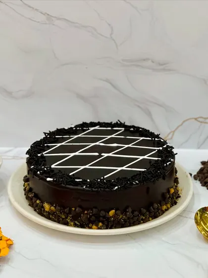 My Chocolate Celebration cake is perfect for everyday celebrations. It's topped with chocolate sprinkles and a classic white chocolate lattice design, making it a simple and delicious choice for any occasion.