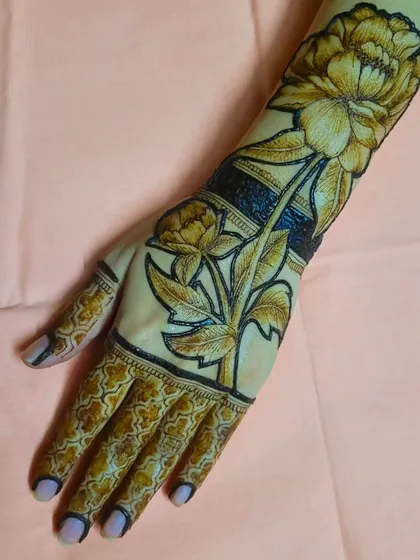 Beyond portraits, I have a passion for realistic floral henna. This design features a large, blooming peony with detailed petals and leaves, creating a bold and elegant statement piece that wraps around the arm.