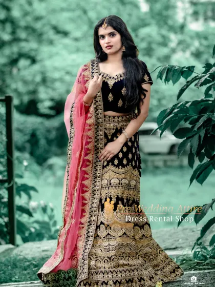 A dark blue velvet lehenga with gold embroidery, paired with a contrasting pink dupatta. The rich colors create a royal and sophisticated look.