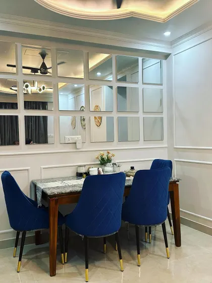 Another view of the Jasola dining area, showing how the mirrored panels are framed to look like a window, a classic design technique to open up a room.