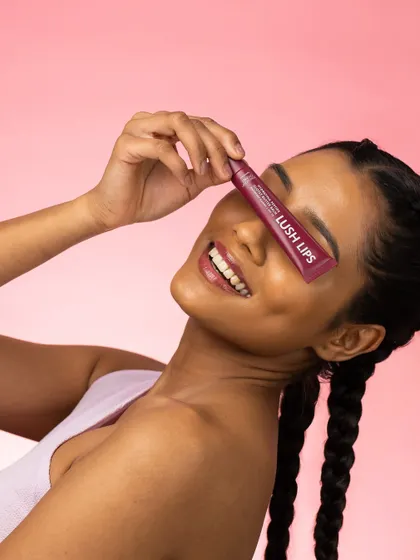 Fun and carefree. This playful pose, where the model covers her eye with the product, creates a memorable and joyful image that perfectly captures the spirit of the "Lush Lips" brand.