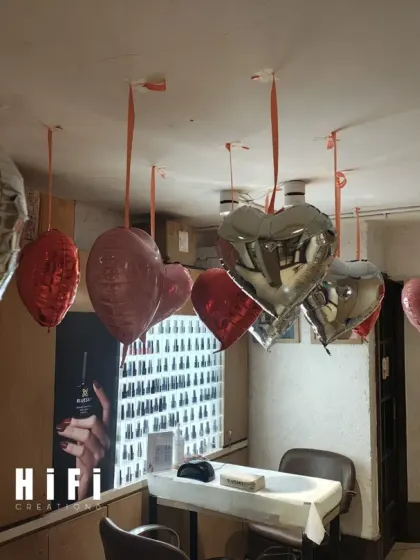 This image shows a simple cluster of hanging heart balloons. Even a small arrangement like this can effectively bring a festive, seasonal feeling to a specific corner or station within a retail store or office.