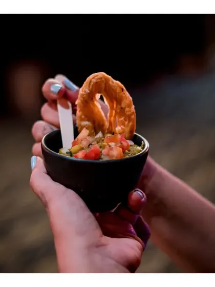 A guest enjoying our Ghugni Chaat, an Indian street food classic, elegantly served in a small bowl for easy handling.