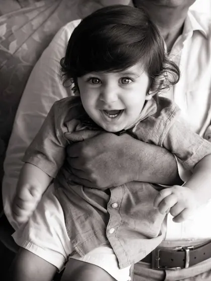 Sometimes, taking away the color lets the emotion shine through. This classic black and white portrait focuses on that bright-eyed smile and the secure feeling of being held, creating a timeless image that will never fade.