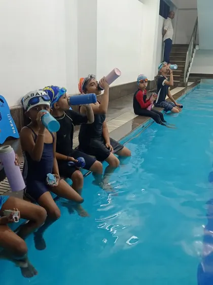Another shot of swimmers rehydrating, emphasizing the importance of rest and recovery during lessons.