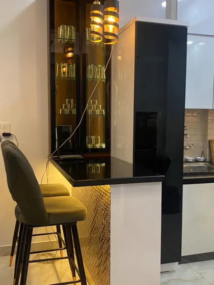 A stylish breakfast counter with seating, integrated into the kitchen layout. The design includes a beautiful crockery unit and pendant lighting, making it a perfect spot for casual meals.