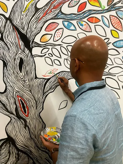 A participant carefully adding a small bird to the branches of our collective tree mural. It's the small, individual details that make the whole so special.