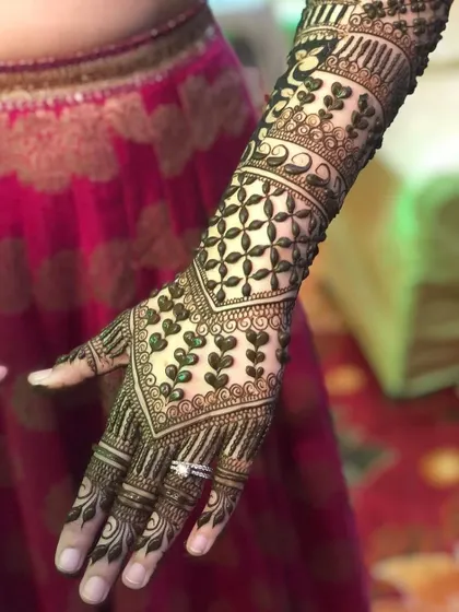 A gorgeous back-hand design featuring delicate heart-shaped leaves and intricate net patterns. This style is perfect for an engagement or sangeet ceremony.