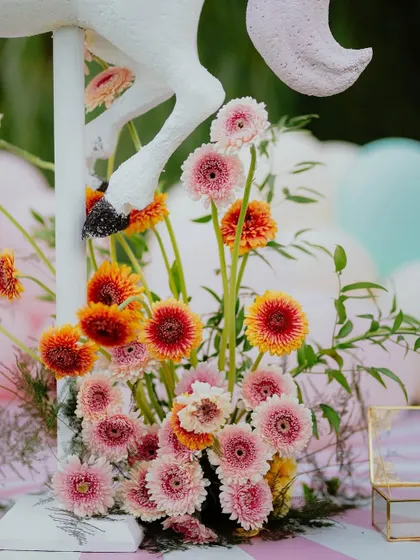 A beautiful arrangement of fresh gerbera daisies adds a pop of vibrant color to the carousel cake station.