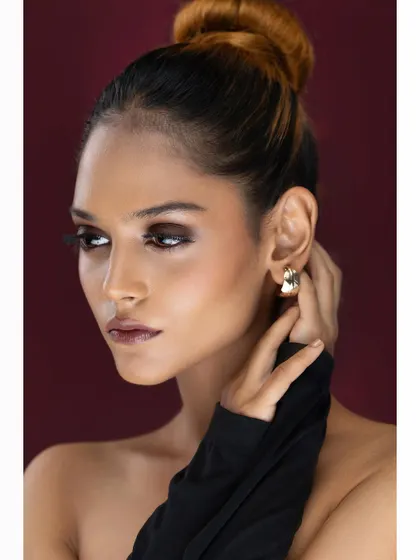 A different angle of the same editorial look, showing the model's profile. The clean lines and dramatic makeup create a powerful and sophisticated image.