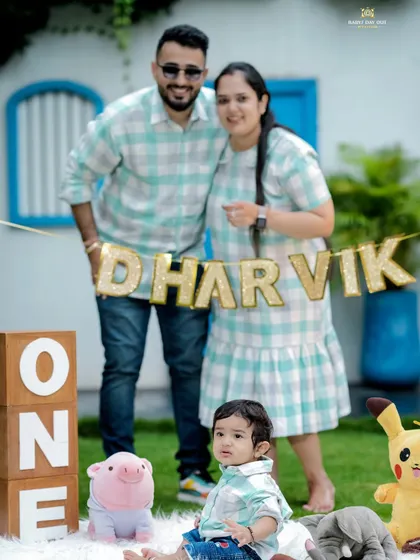 A cheerful first birthday celebration outdoors. This family's matching outfits and the festive "ONE" blocks create a picture perfect memory of this important family milestone.