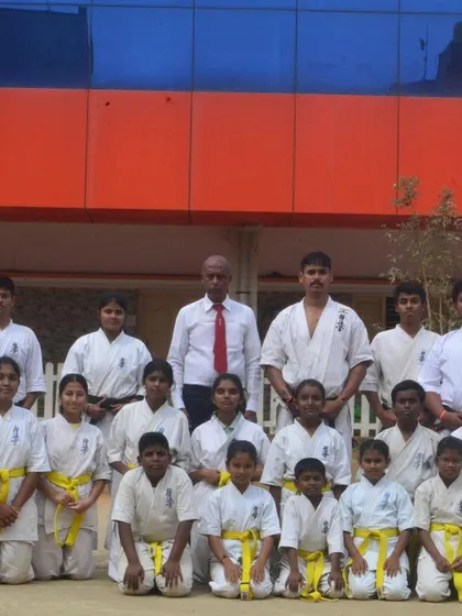 The yellow belt students stand proudly with their seniors after the belt grading exam. Each level is a step forward on the path.