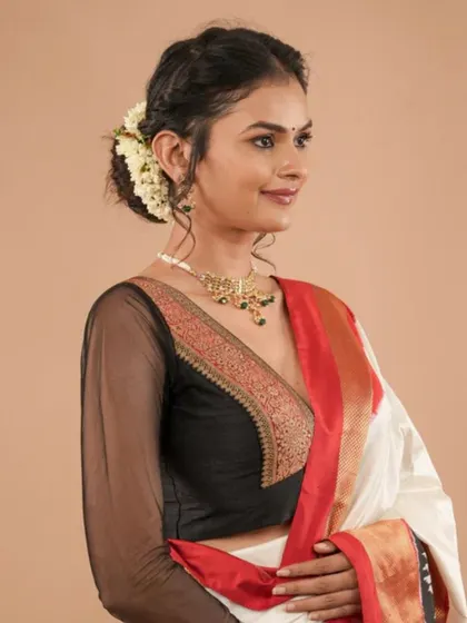 This model wears a simple gold choker that complements the gold brocade detailing on her black blouse.