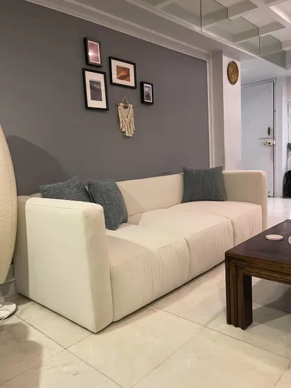 Another view of the sofa in a home, paired with a dark wood coffee table and accent decor.