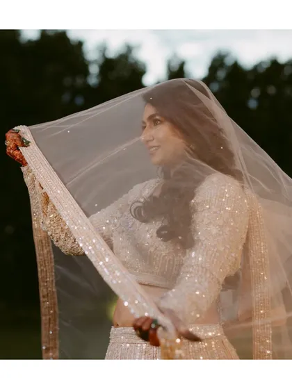 A bride twirls in her sparkling lehenga, her veil catching the light. A moment of pure magic and elegance.