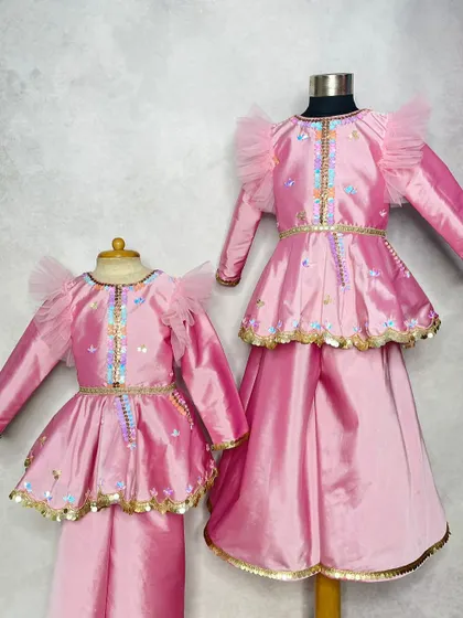 Grace in every stitch. This matching sister set in pink silk features delicate embroidery and sequin details, designed for little trendsetters who love a bit of sparkle.