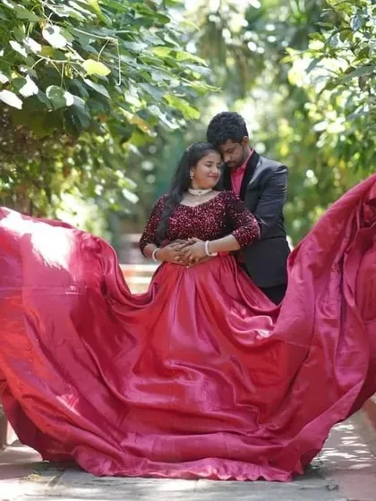 The full splendor of the red satin trail gown is on display here. It's an ideal choice for couples who want their pre-wedding photos to have a touch of grandeur and drama.