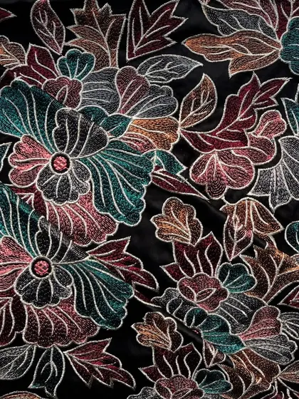 A close-up of our embroidered satin on a black base, showcasing the intricate and colorful floral threadwork that makes it so special.
