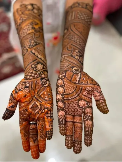 This photo shows the beautiful orange-to-red color of a fresh henna stain. The design is a mix of modern Arabic flow and traditional Indian details.