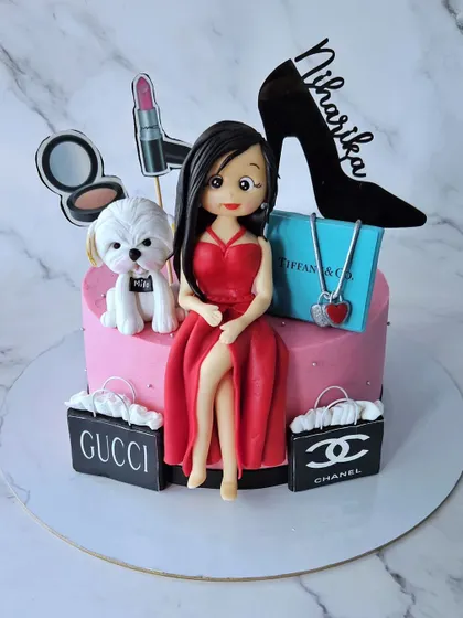 Behind every pretty girl is a cute lil pup! This cake for Niharika features a figurine in a red dress, her puppy, and all her favorite luxury brands.