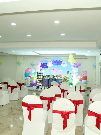 A wide view of a party hall set up for a Peppa Pig theme. This shows how I arrange the seating to ensure all guests have a great view of the main stage.