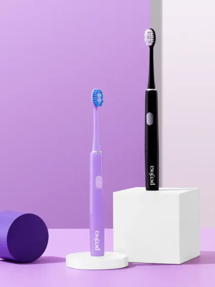 A clean and simple hero shot of two Perfora electric toothbrushes. The minimalist composition against a purple background highlights the sleek design of the products.
