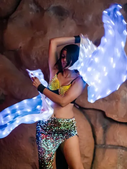 A graceful pose with the LED veil fans. This prop is perfect for belly dance fusion and other performances that require fluid, elegant movements.