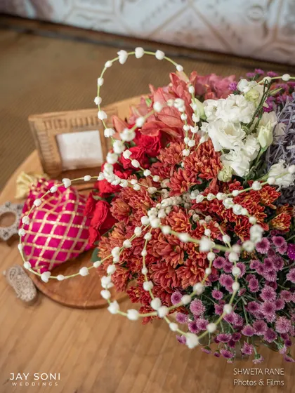 An overhead shot of a floral arrangement, showing the beautiful textures and the delicate strings of jasmine woven through it.